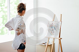 Artist analyze her painting in art studio
