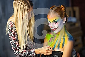 The artist applies body art to a lovely woman