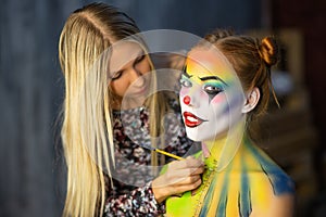 The artist applies body art to a pretty woman