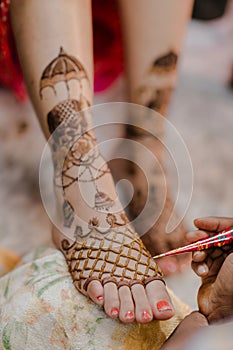 Artist applying henna tattoo on women hands.