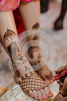 Artist applying henna tattoo on women hands.