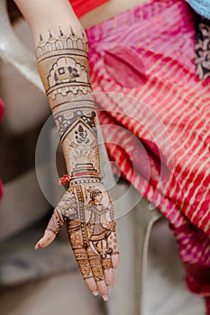 Artist applying henna tattoo on women hands.