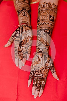 Artist applying henna tattoo on women hands.