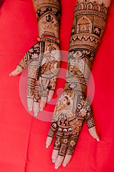 Artist applying henna tattoo on women hands.