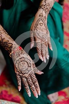 Artist applying henna tattoo on women hands.