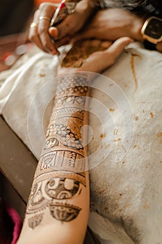Artist applying henna tattoo on women hands. Mehndi is traditional Indian decorative art. Close-up