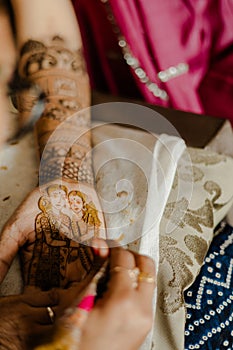 Artist applying henna tattoo on women hands. Mehndi is traditional Indian decorative art. Close-up