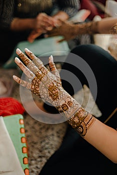 Artist applying henna tattoo on women hands. Mehndi is traditional Indian decorative art. Close-up