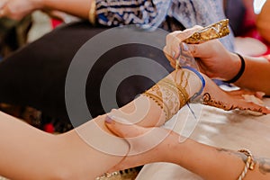 Artist applying henna tattoo on women hands. Mehndi is traditional Indian decorative art. Close-up