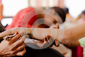 Artist applying henna tattoo on women hands. Mehndi is traditional Indian decorative art. Close-up