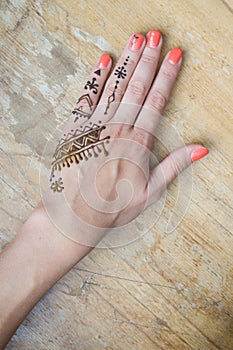 Artist applying henna tattoo on women hands. Mehndi is traditional Indian decorative art. Close-up, overhead view - beauty concept