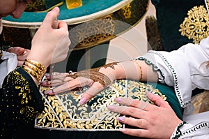 Artist applying henna tattoo on women hands. Mehndi is traditional moroccan decorative art
