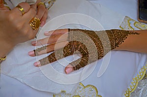 Artist applying henna tattoo on women hands. Mehndi is traditional moroccan decorative art.