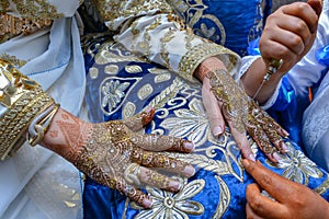 Artist applying henna tattoo on women hands. Mehndi is traditional moroccan decorative art.