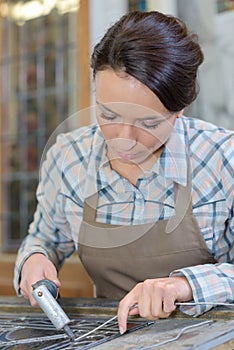 Artist applying lead to glass