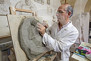 Artist in the art studio at work on a clay sculpture