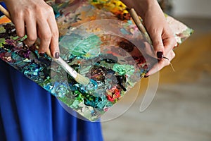 artist brush mix color oil painting on palette is holding in her