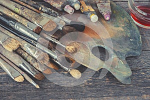 Artist brushes and tubes with paint on the palette