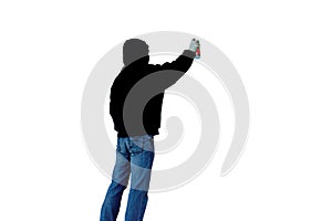 Artist with can of spray paint draws graffiti picture isolated on a white background in black hood unknown back view