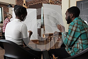 Artist collegues sitting in front on canvas drawing vase model