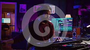 Artist composing a song on electronic piano keyboard at home recording studio