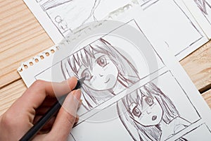 Artist drawing an anime comic book in a studio