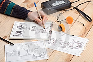 Artist drawing an anime comic book in a studio. Wooden desk, natural light. Creativity and inspiration concept