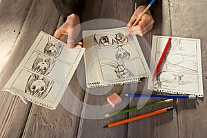 Artist drawing an anime comic book in a studio. Wooden desk, natural light. Creativity and inspiration concept