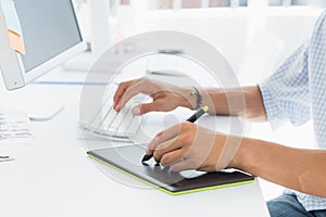 Artist drawing something on graphic tablet with pen