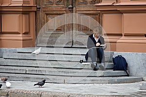 The artist draws sitting on the steps