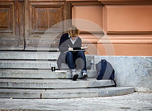 The artist draws sitting on the steps