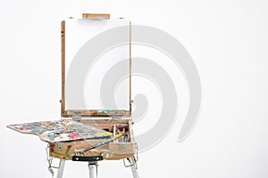 Artist easel with blank canvas on a white background.