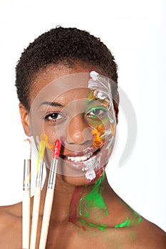 Artist in facepaint holding brushes