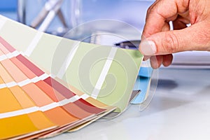 Artist hand browsing color samples in palette