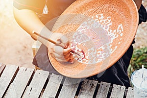 Artist hand painting earthenware with traditional sukhothai styel