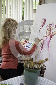 Artist in her fifties painting