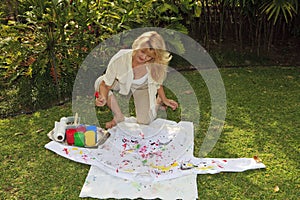 Artist in her fifties painting a shirt