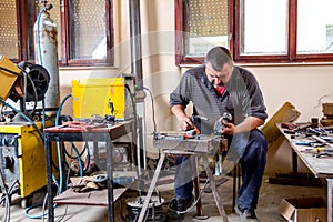 Artist is making figure by welding few metal wires in his workshop, barehanded