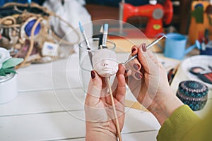 The artist making a new doll face at the toy factory. The master artist processes the doll`s head.