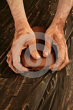 Artist man hands working red clay for handcraft photo