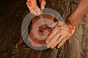 Artist man hands working red clay for handcraft photo