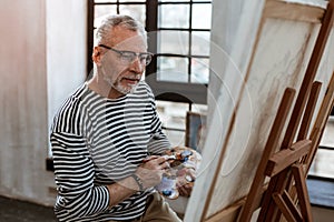 Artist mixing some watercolor while painting on canvas