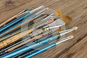 Artist paint brushes over rustic wooden texture