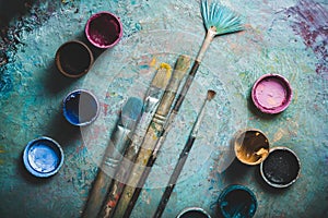 Artist paint brushes and paint cans of paint over