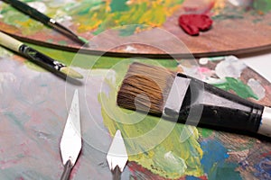 Artist paint brushes,palette knifeand oil paint on wooden artist