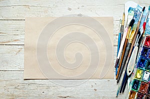 Artist paint brushes on the wooden background