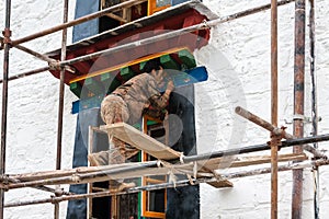 Artist paint decorating tibetan monastery in lhasa