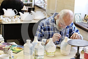 The artist painting ceramic bottles