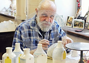 The artist painting ceramic bottles