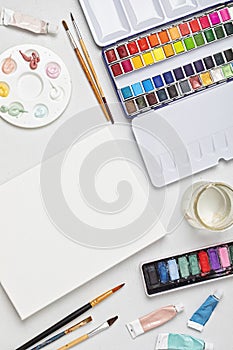 Artist painting color palettes, brushes and white canvas. Craft hobby background
